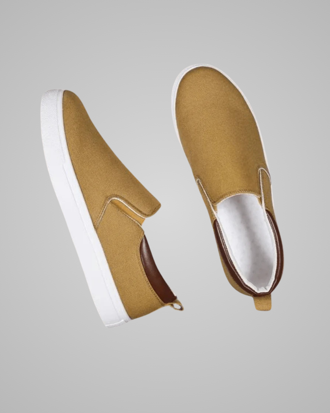 A pair of slip-on canvas sneakers in a mustard yellow color with white soles and a brown heel accent, shown from two angles on a solid gray background.