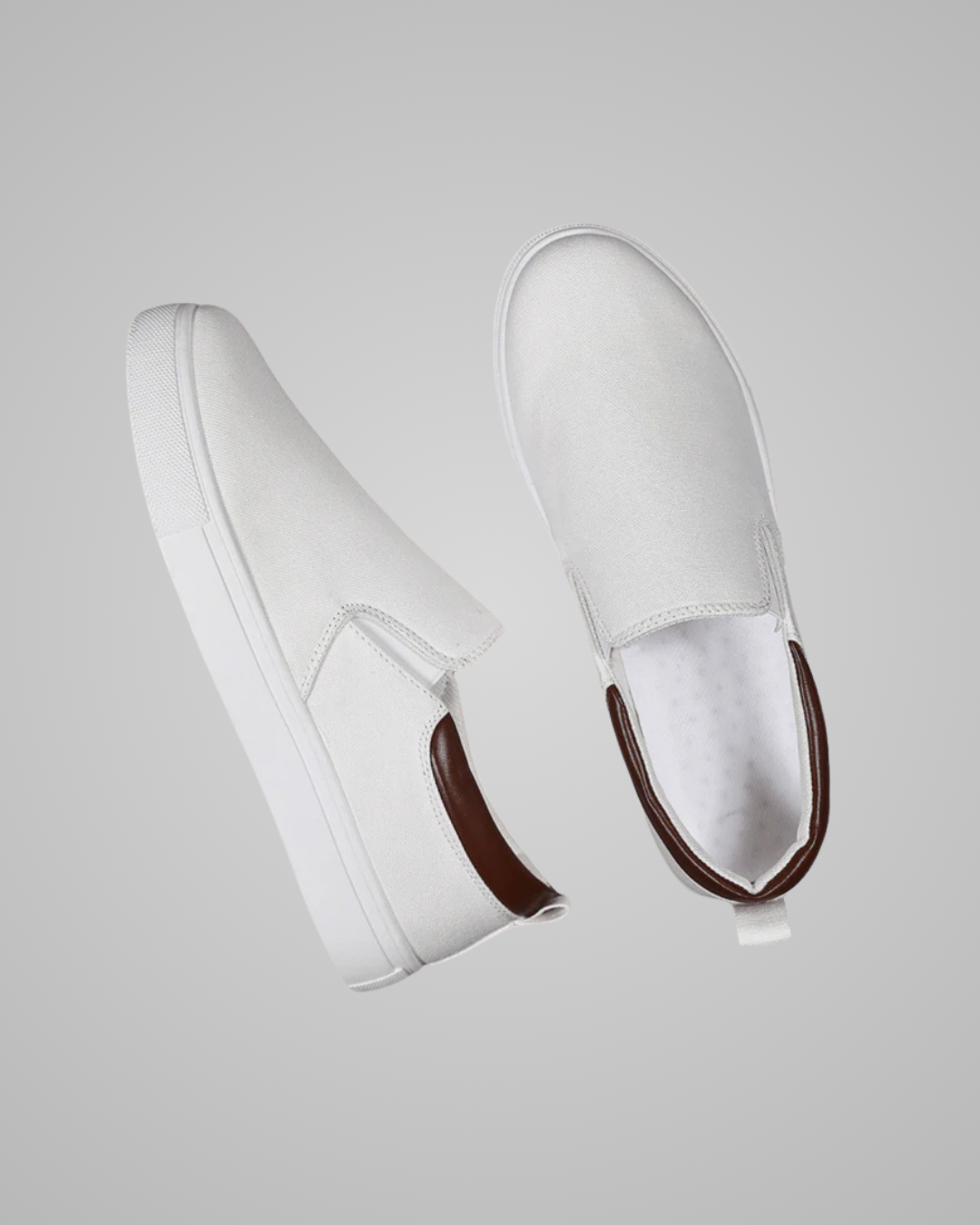 A pair of white slip-on platform sneakers with dark brown heel accents, shown from side and top-down angles against a solid gray background.