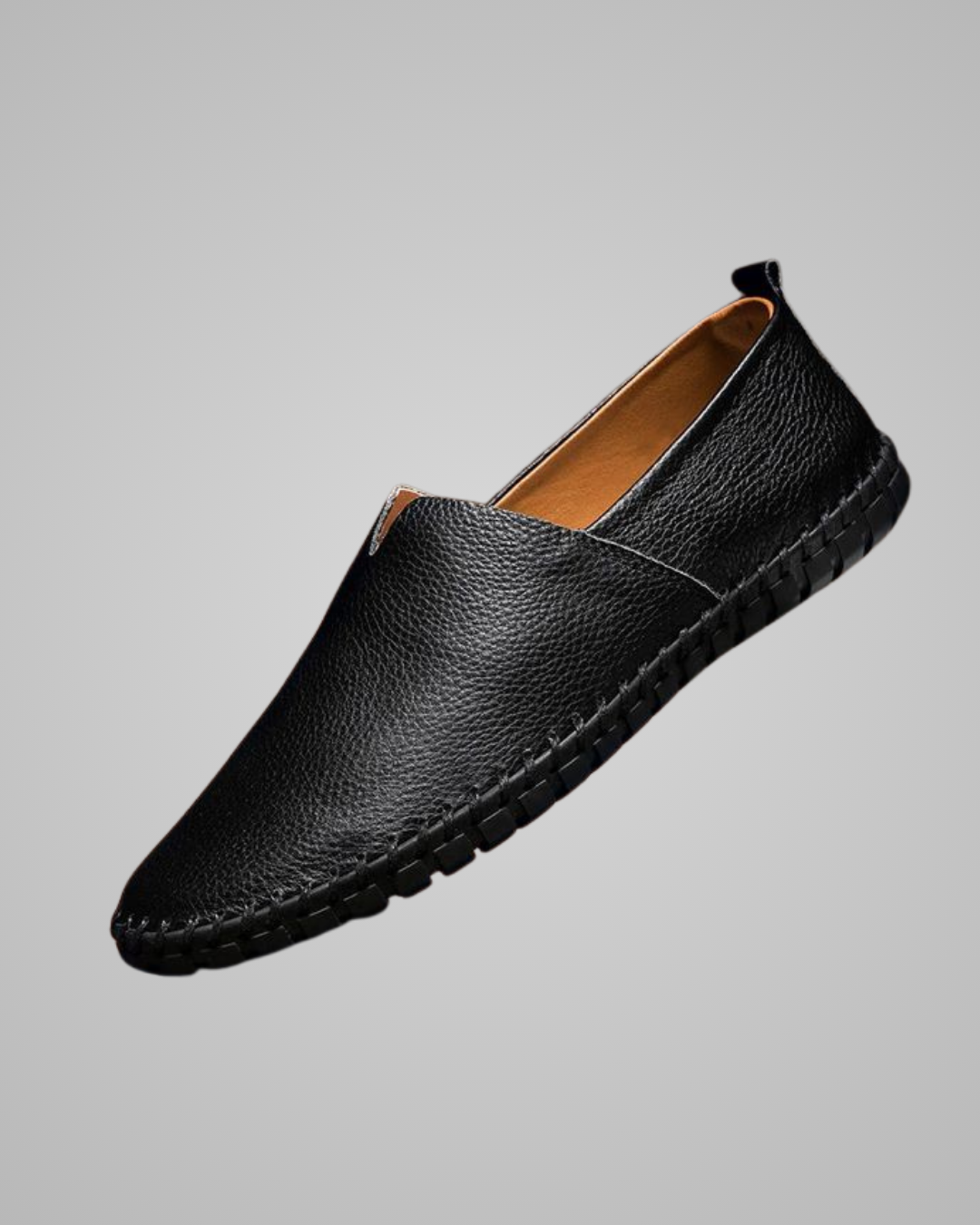 Black leather loafer shoe on a gray background
