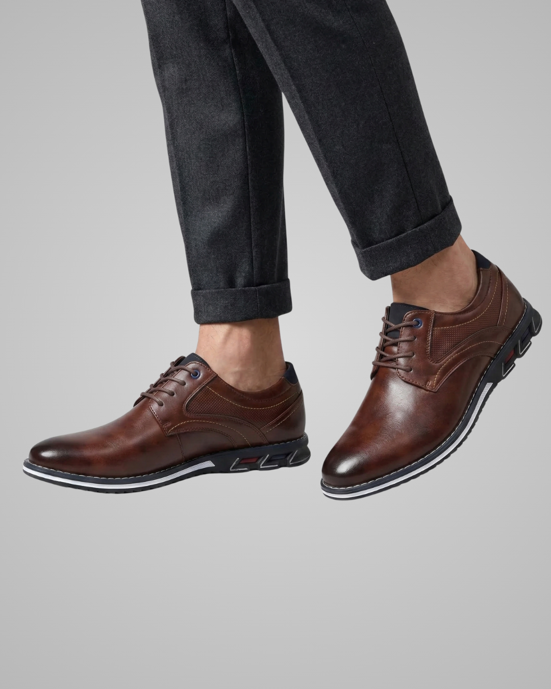 Brown leather shoes worn with black pants on a light gray background