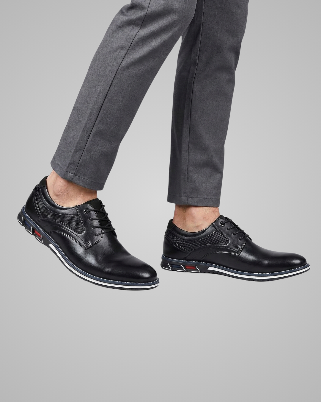Black leather shoes worn with gray pants on a light gray background