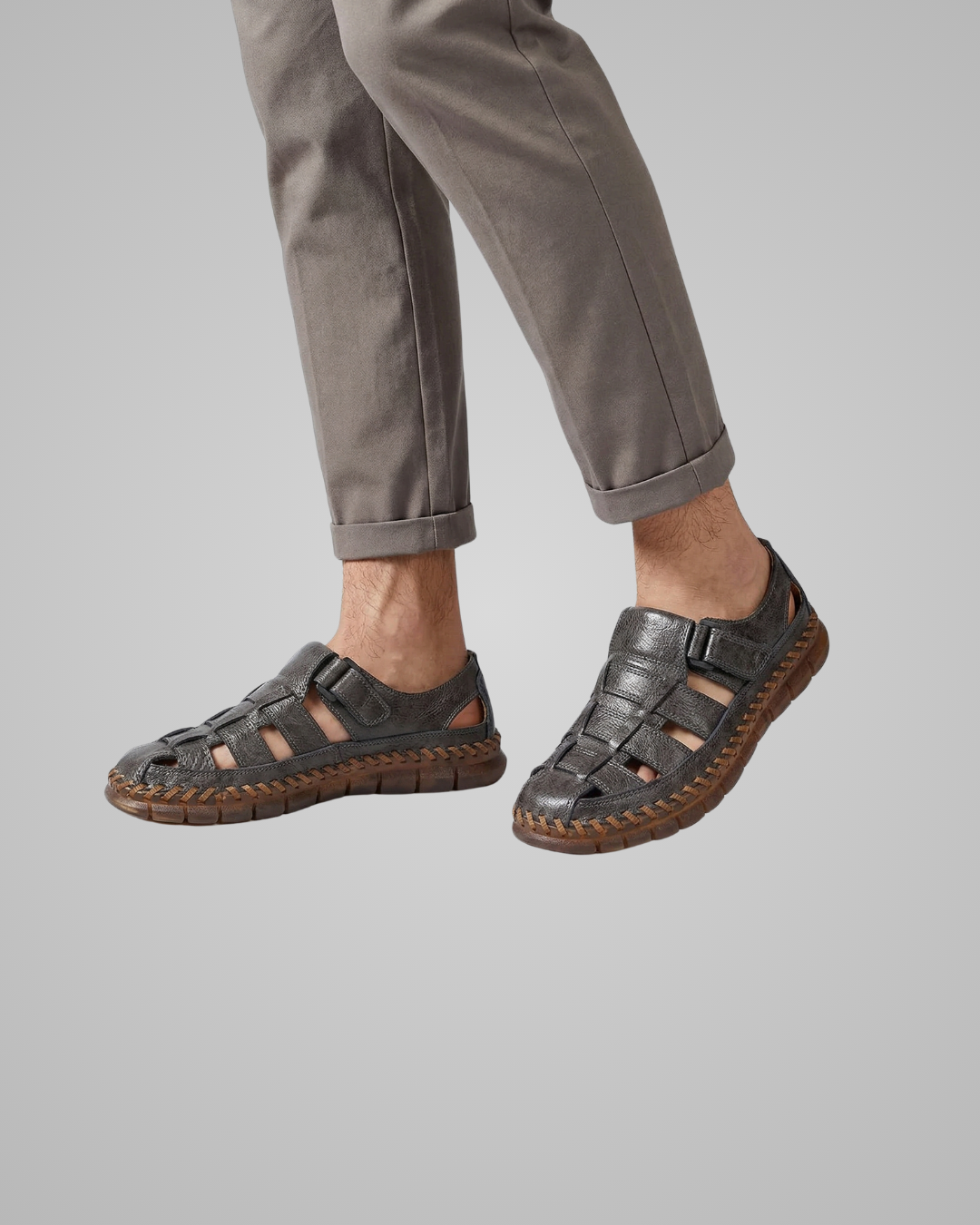 Person wearing gray sandals on a plain background