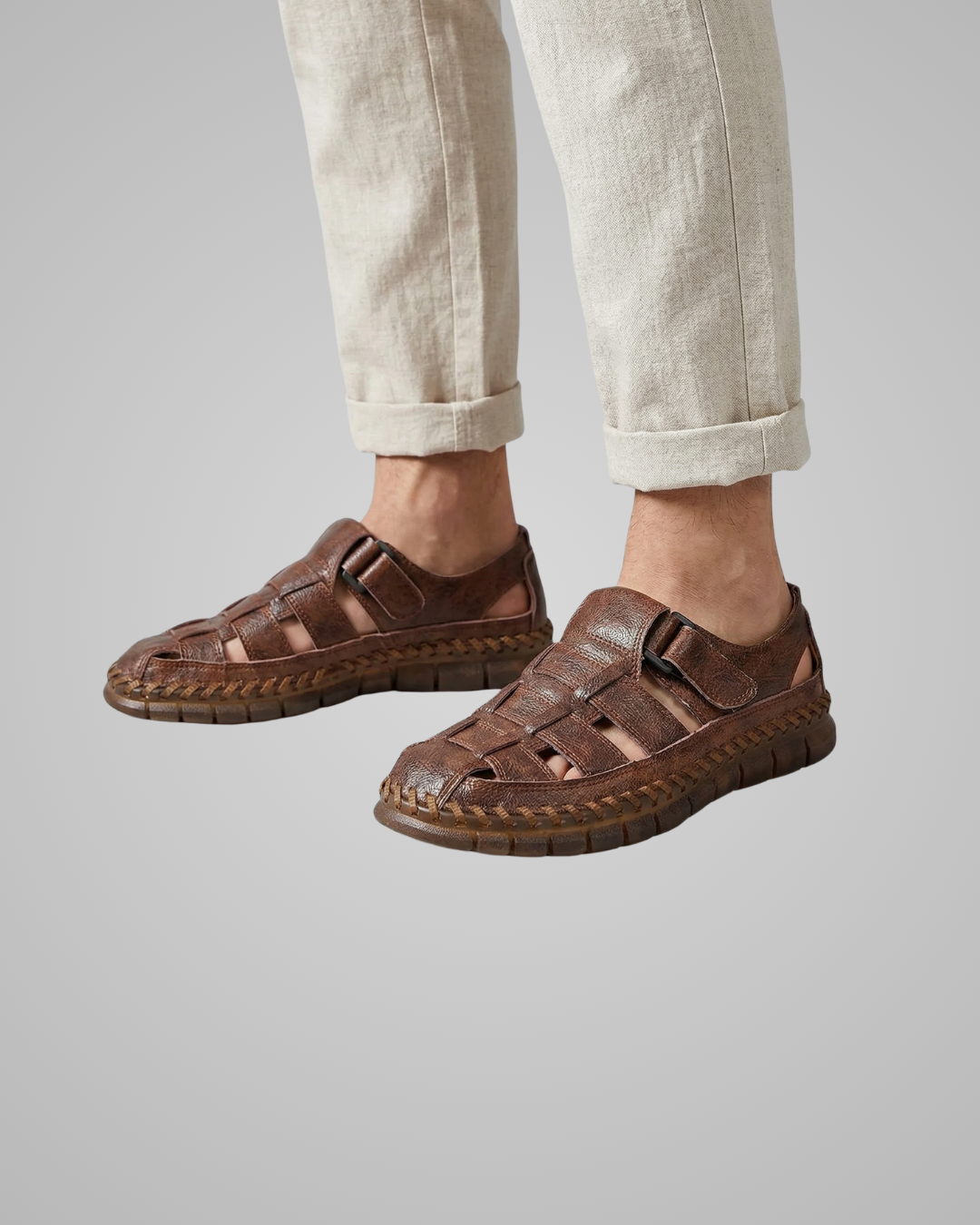 Brown sandals worn with beige pants on a gray background