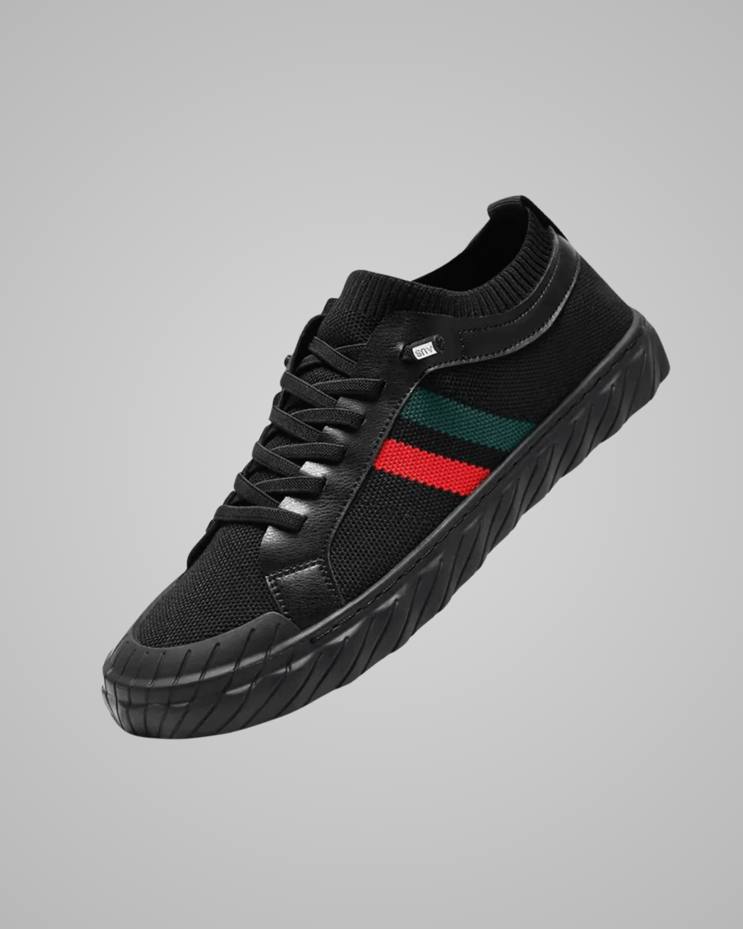 Black sneaker with a red and green stripe on a gray background