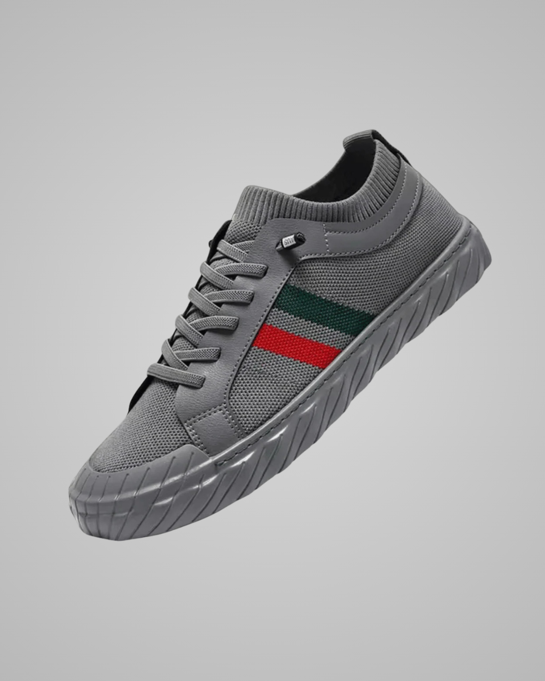 Gray sneaker with a green and red stripe on a gray background
