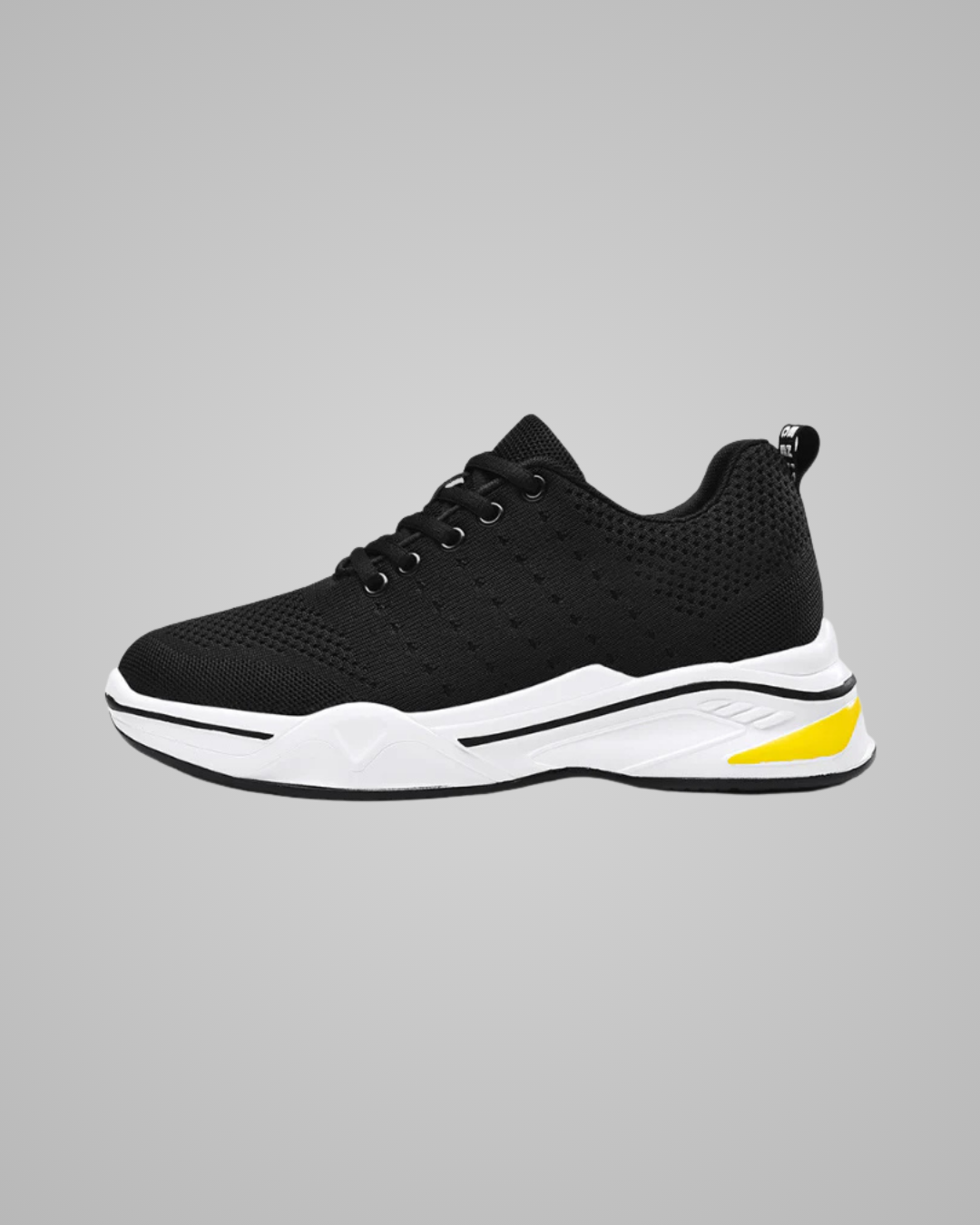 Black sneaker with white sole and yellow accent on a gray background