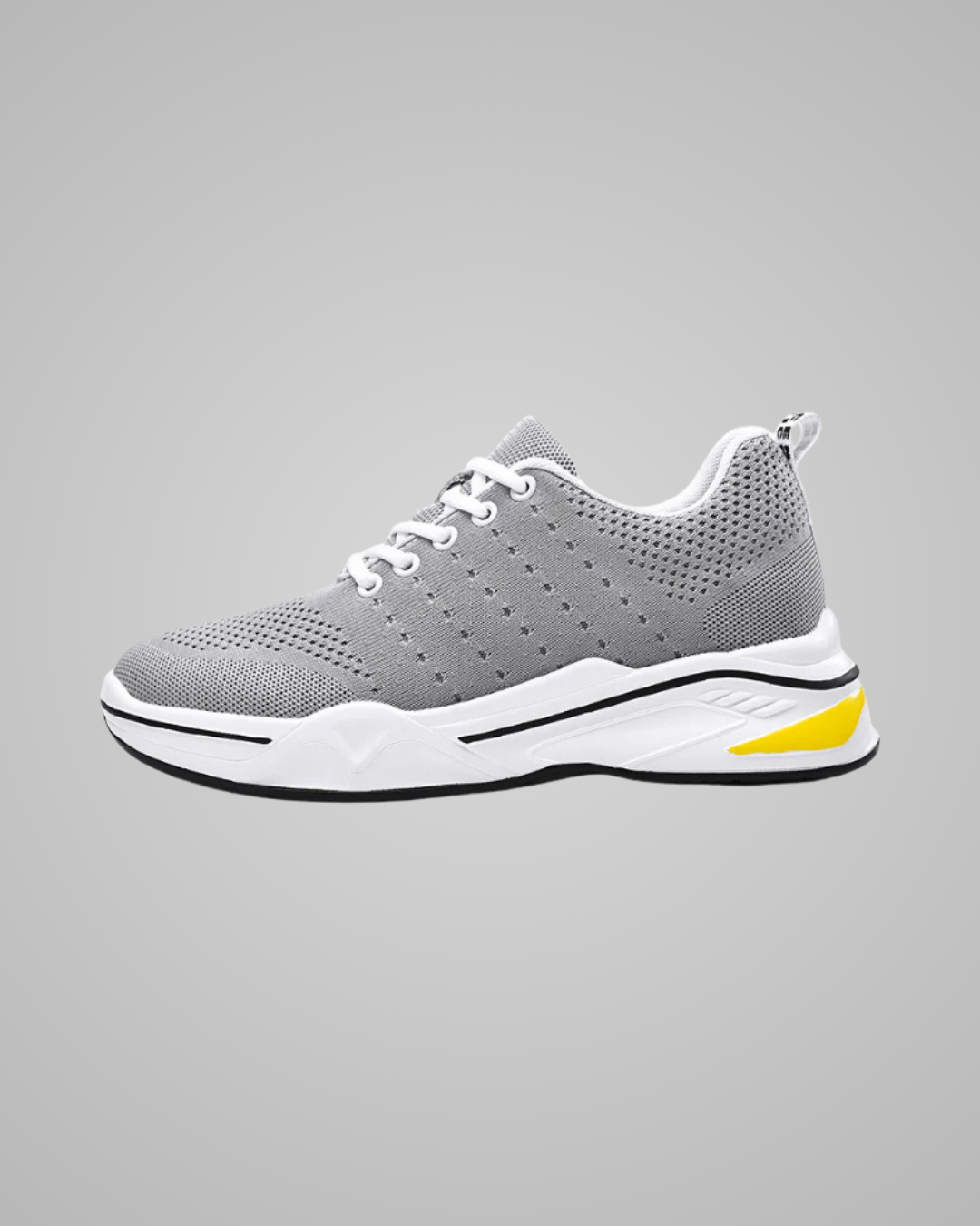Gray athletic shoe with white sole and yellow accent on a gray background