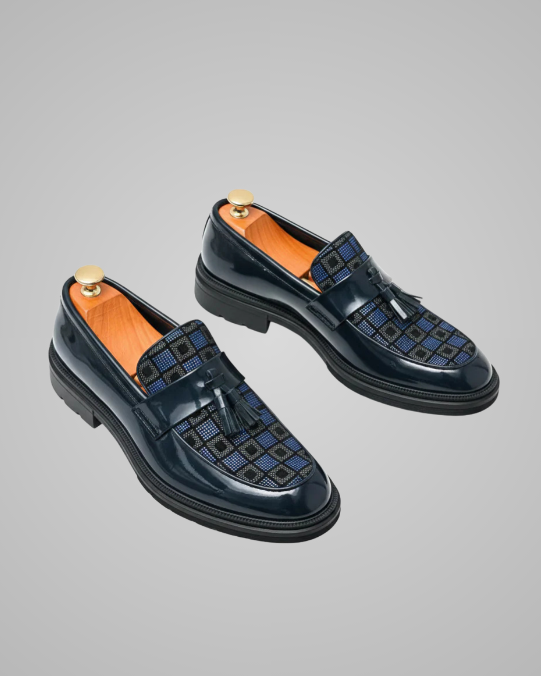 Pair of navy loafers with a textured pattern on a gray background