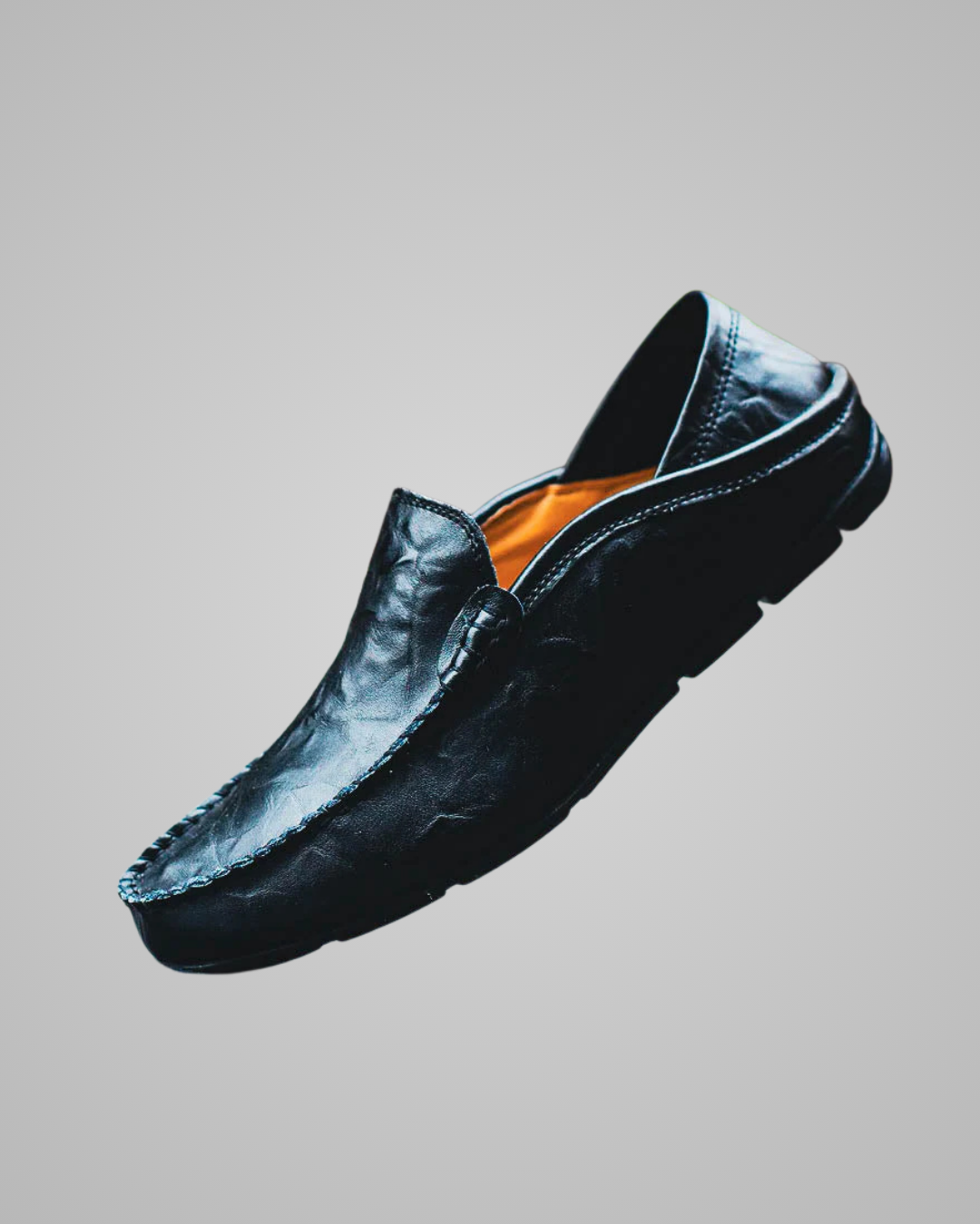 Black loafer shoe on a gray background
