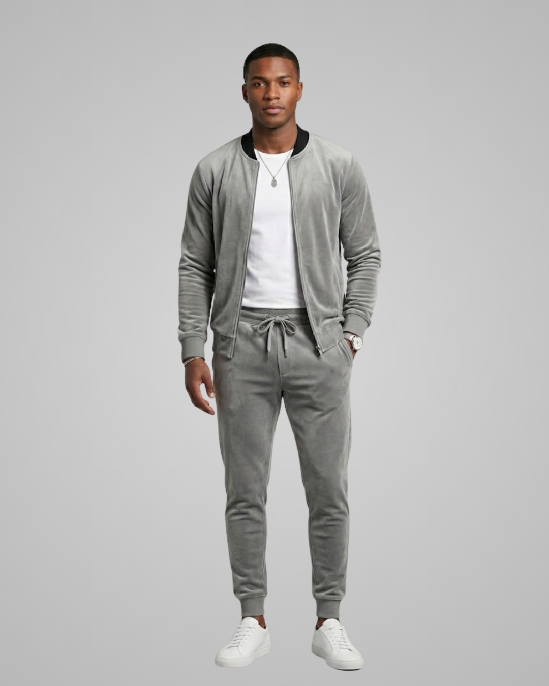 Man wearing a gray tracksuit on a plain background