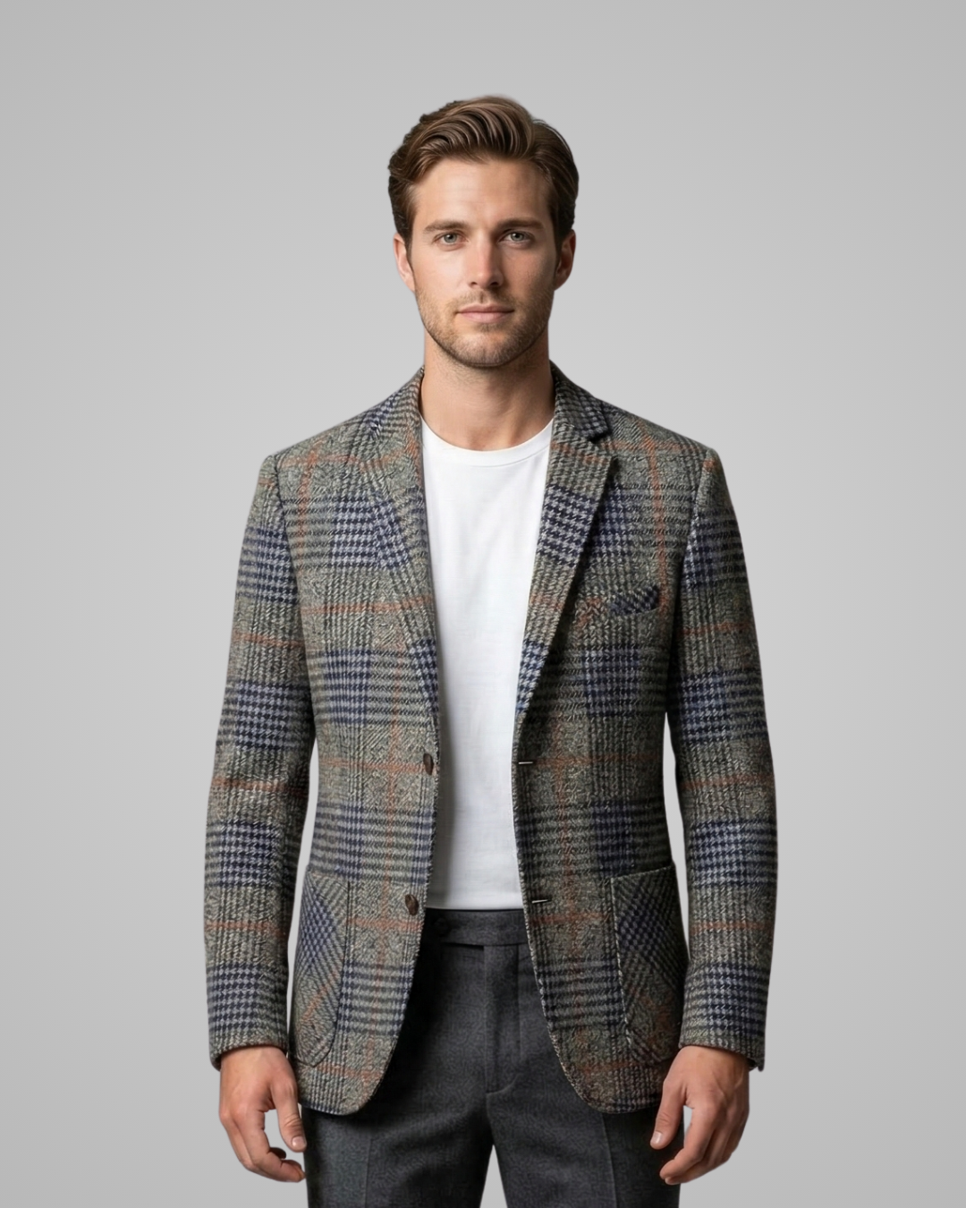 Man wearing a patterned blazer over a white shirt on a gray background