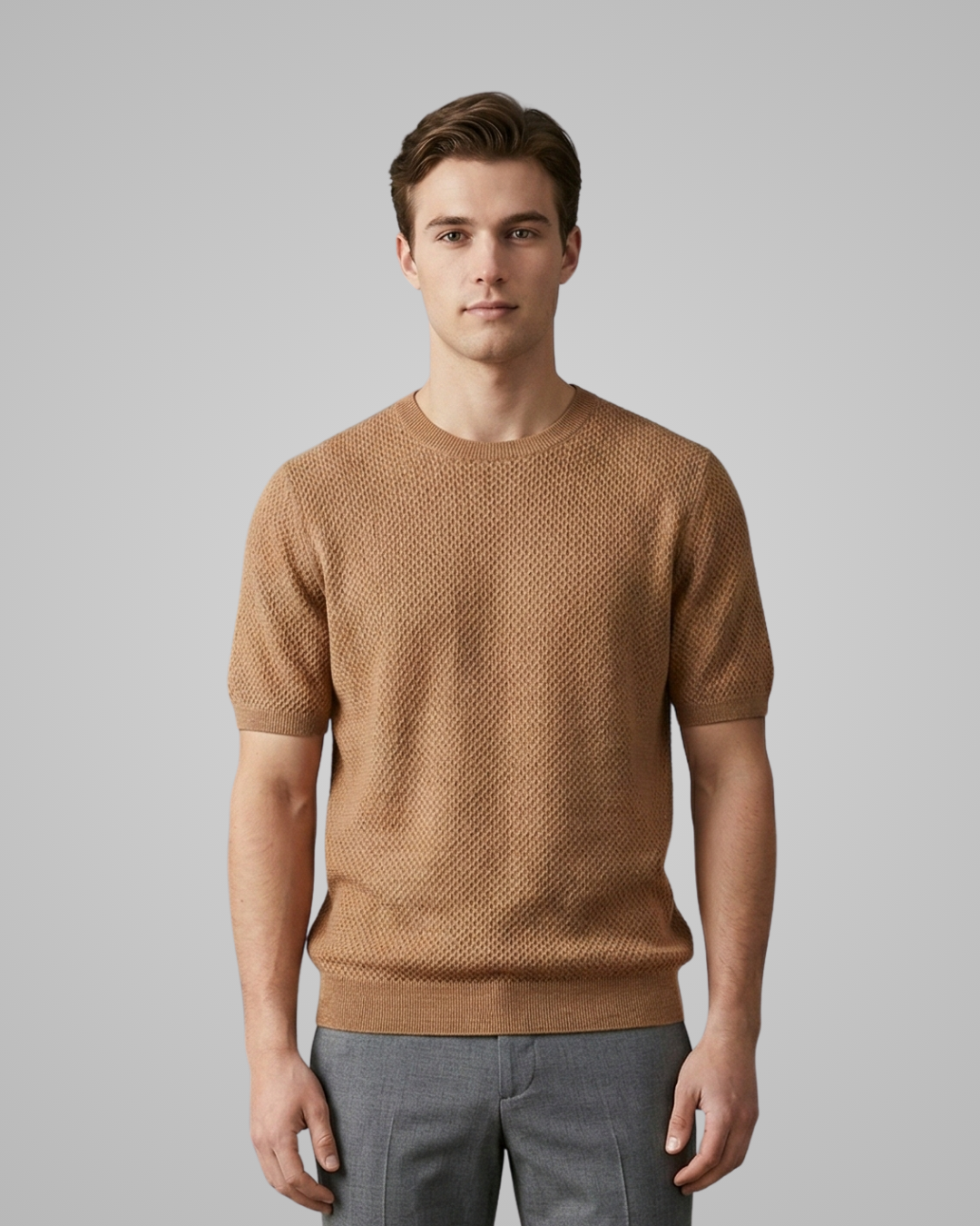 Man wearing a brown textured sweater against a gray background