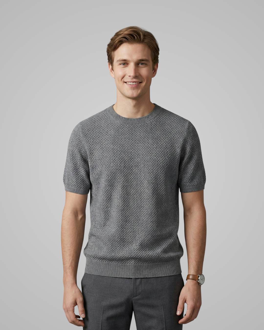 Man wearing a gray patterned sweater against a plain background