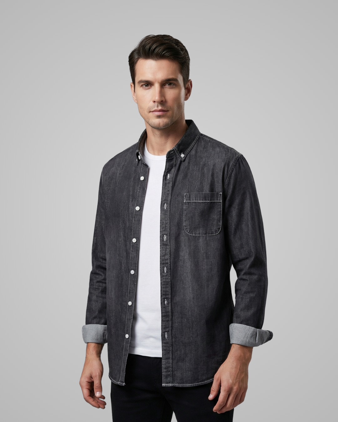 Man wearing a dark denim shirt over a white t-shirt on a gray background