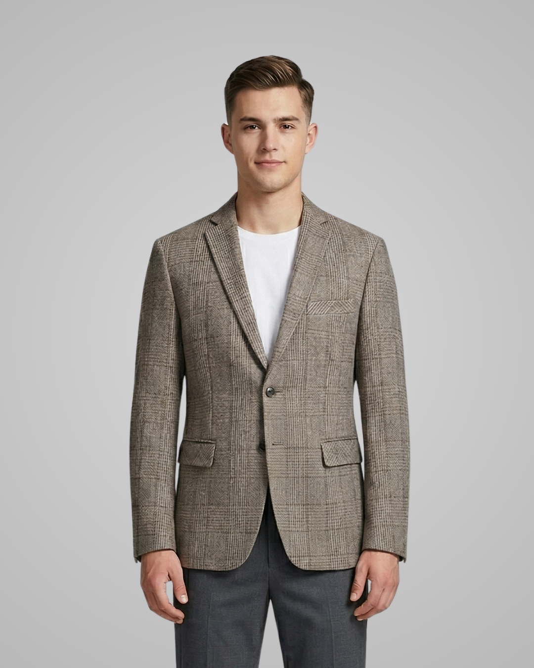 Man wearing a patterned blazer over a white shirt on a gray background