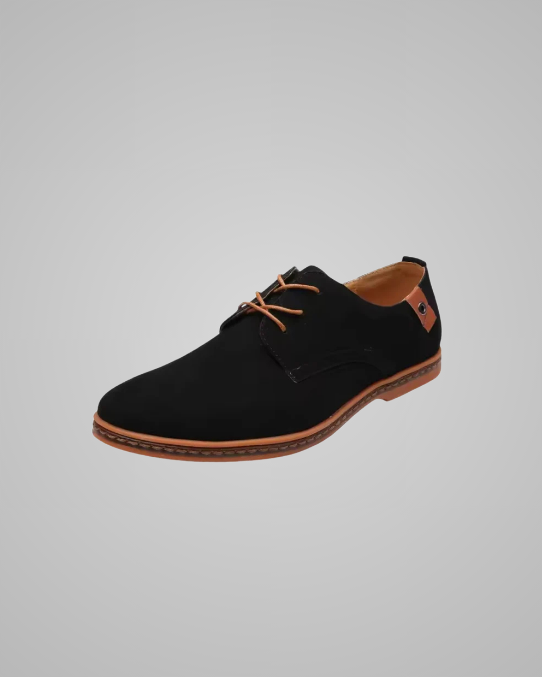 Black suede shoe with brown accents on a gray background