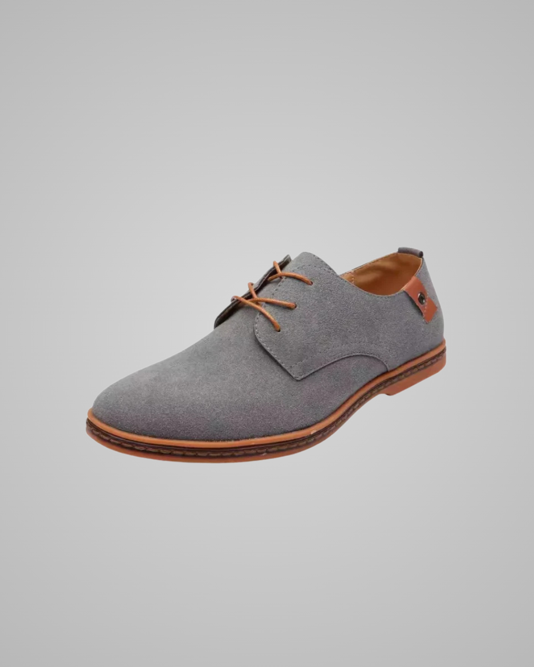 Gray suede shoe with brown accents on a gray background