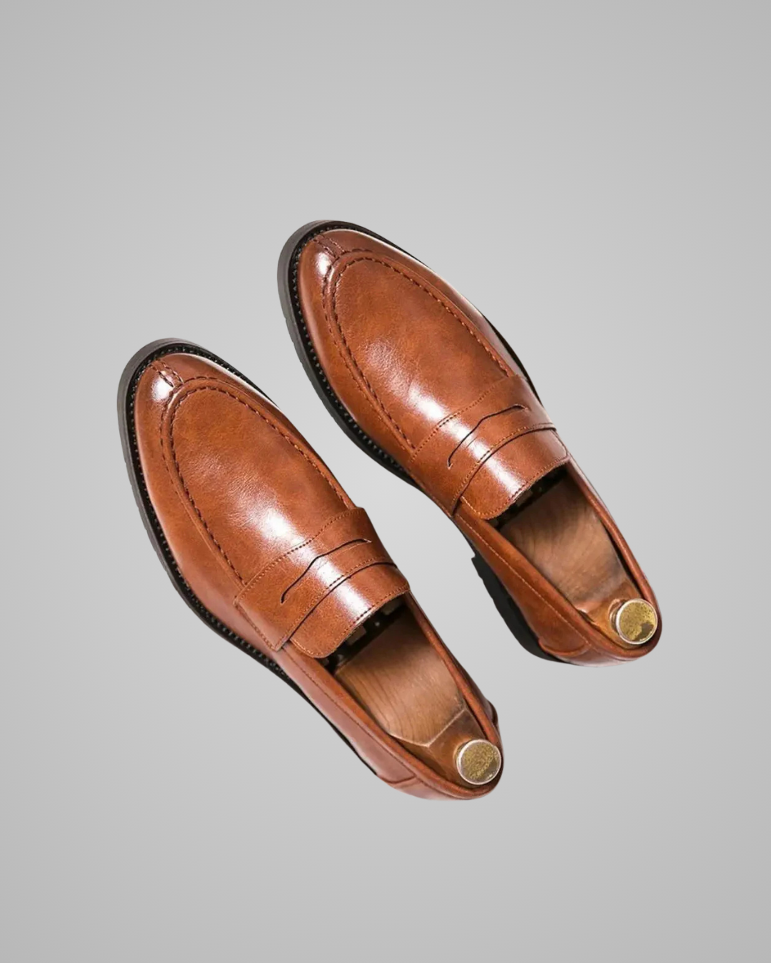 Pair of brown leather loafers on a gray background