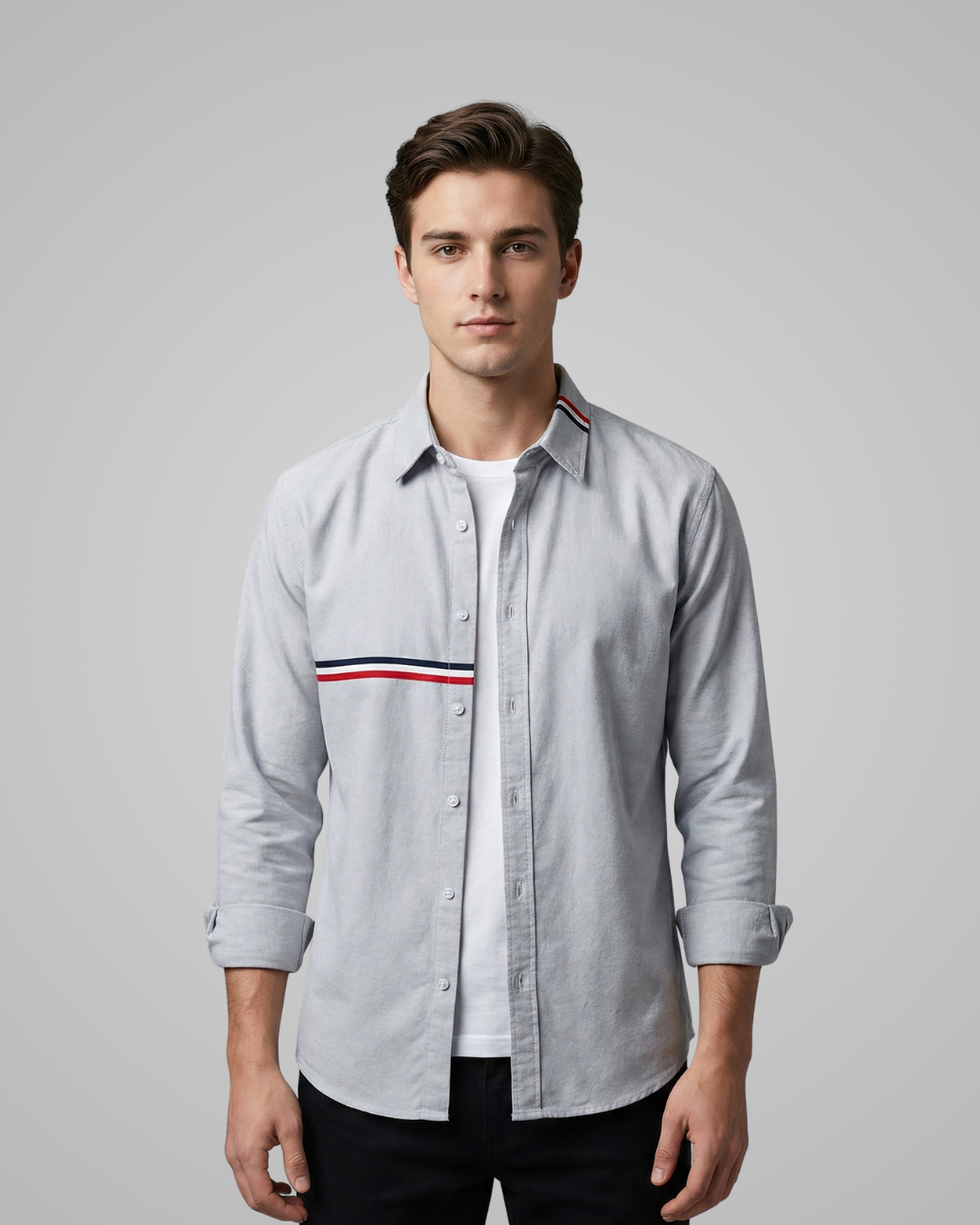 Man wearing a light gray shirt with a brand logo on a gray background