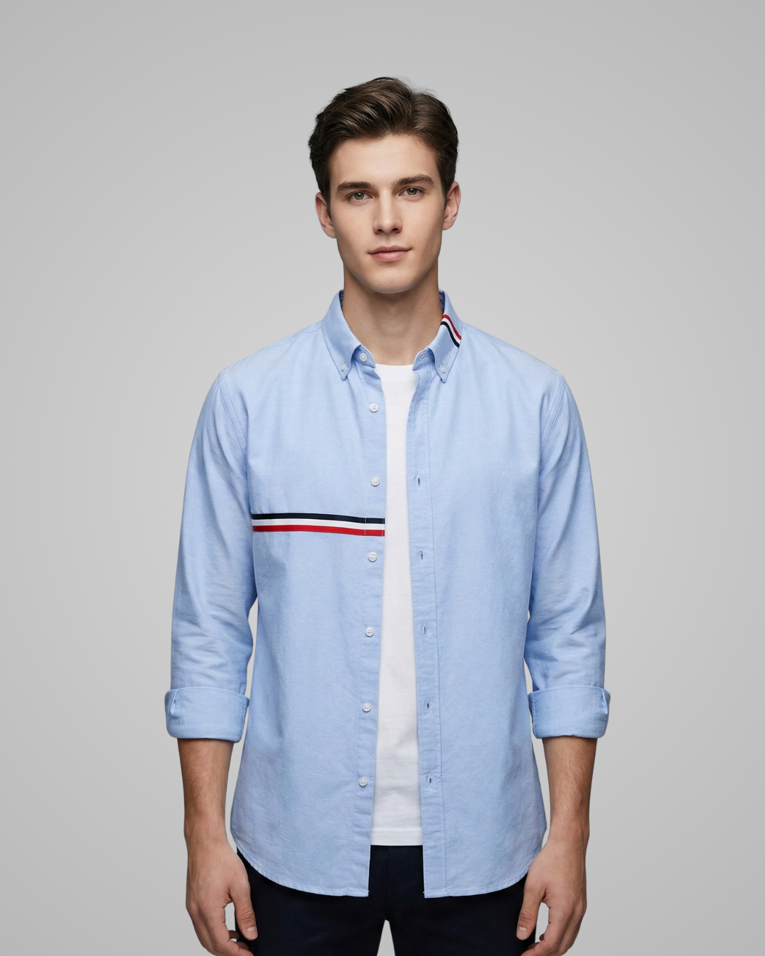 Man wearing a light blue shirt with a white collar against a gray background