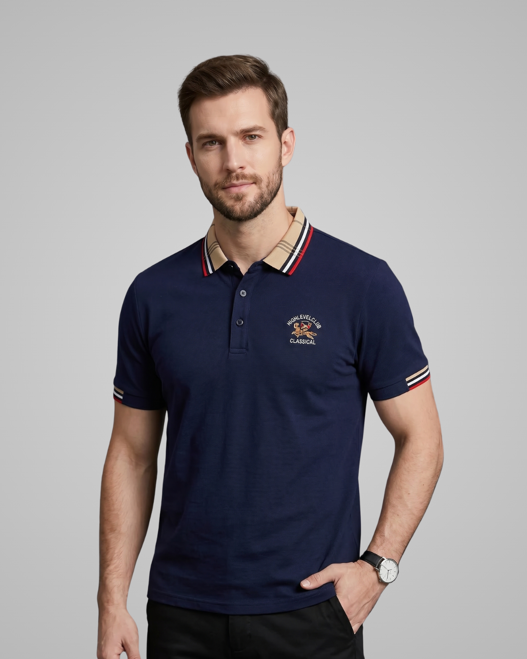 Man wearing a navy blue polo shirt with a brand logo on a gray background