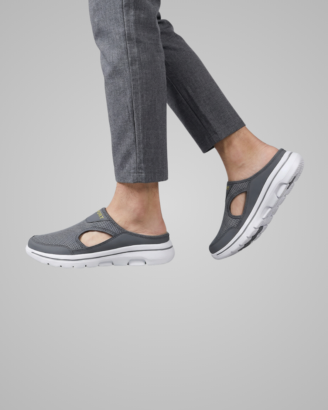Person wearing gray slip-on shoes with a neutral background