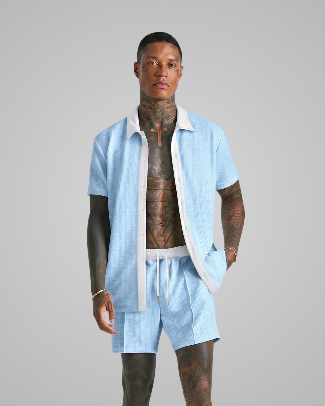 Man wearing a light blue shirt and shorts set on a gray background