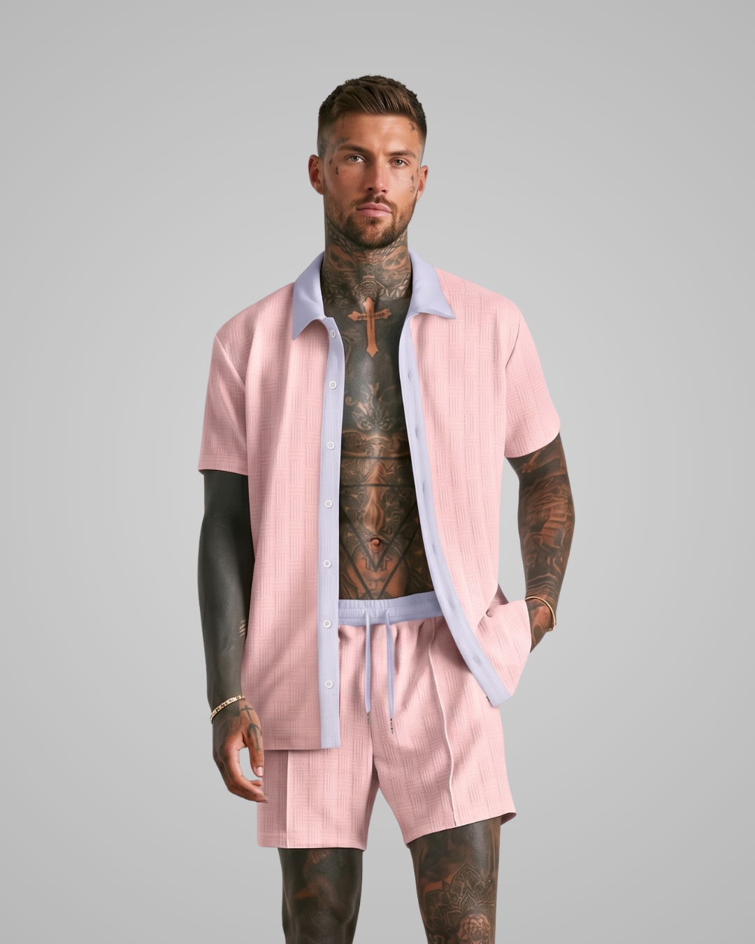Man wearing a pink outfit with tattoos on a gray background