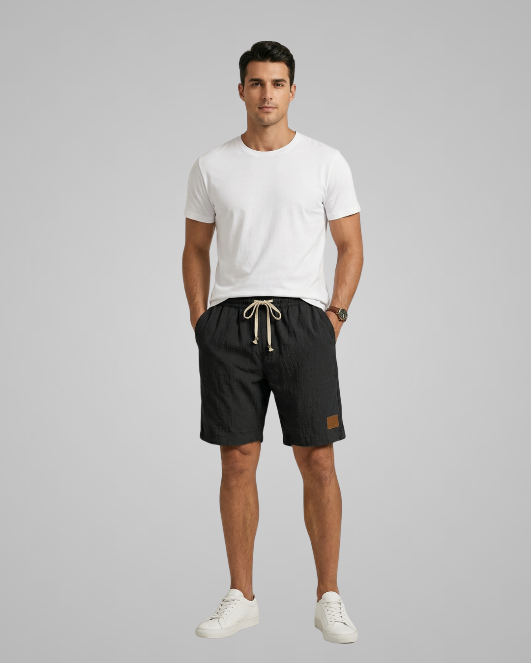 Man wearing a white t-shirt and black shorts on a gray background