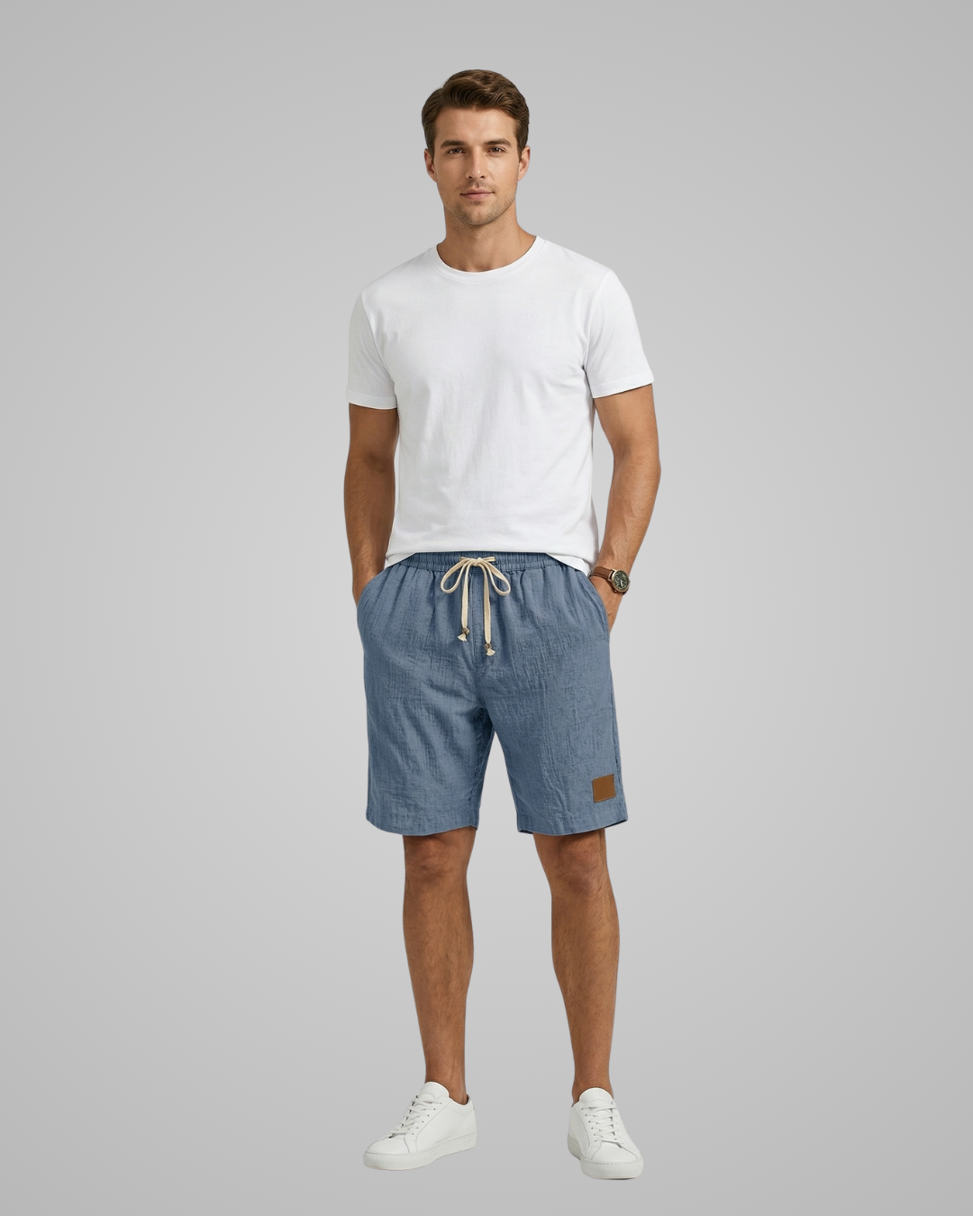 Man wearing a white t-shirt and blue shorts on a gray background