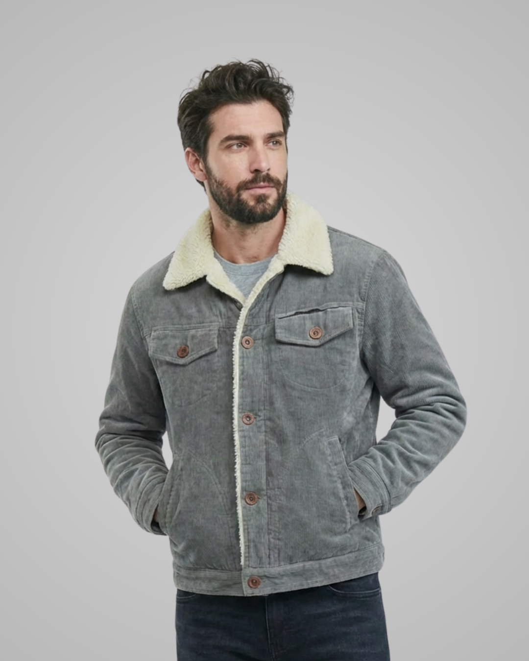 Man wearing a gray denim jacket with white fleece lining on a plain background