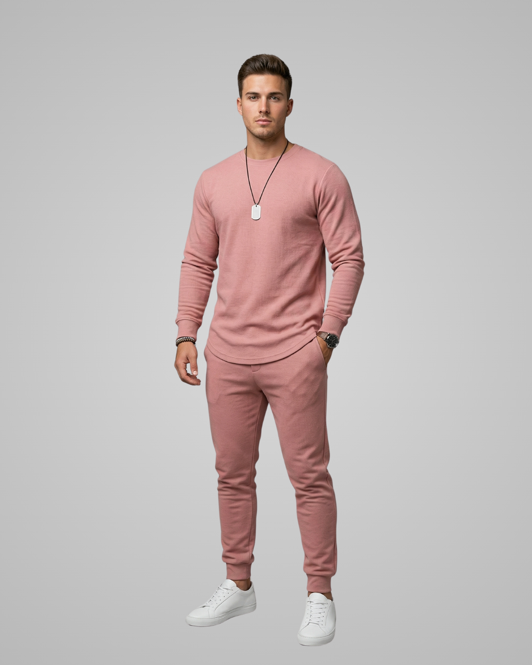 Man wearing a pink outfit with a necklace on a gray background