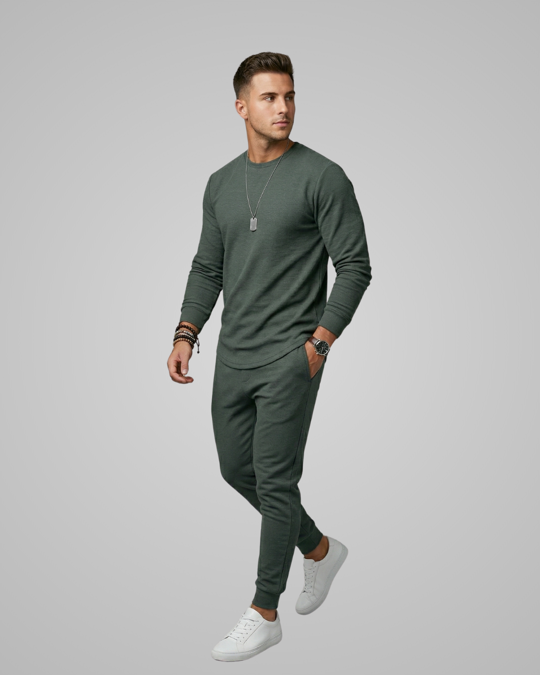 Man wearing a green outfit with white sneakers on a gray background