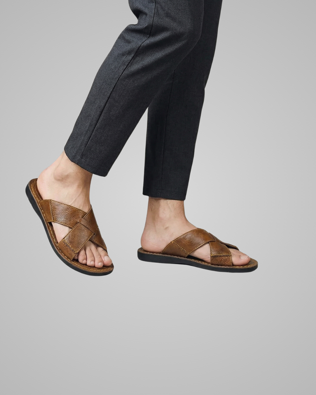 Brown sandals worn with black pants on a gray background