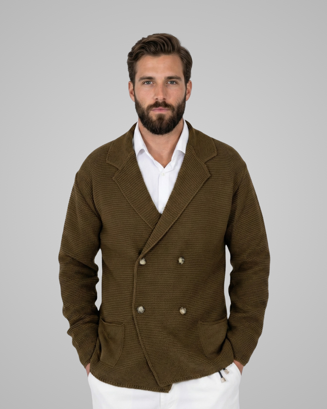 Man wearing a brown blazer over a white shirt on a gray background