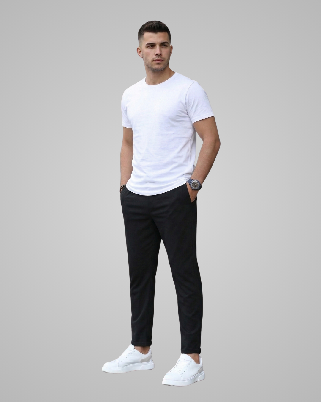 Man wearing a white t-shirt, black pants, and white sneakers on a gray background