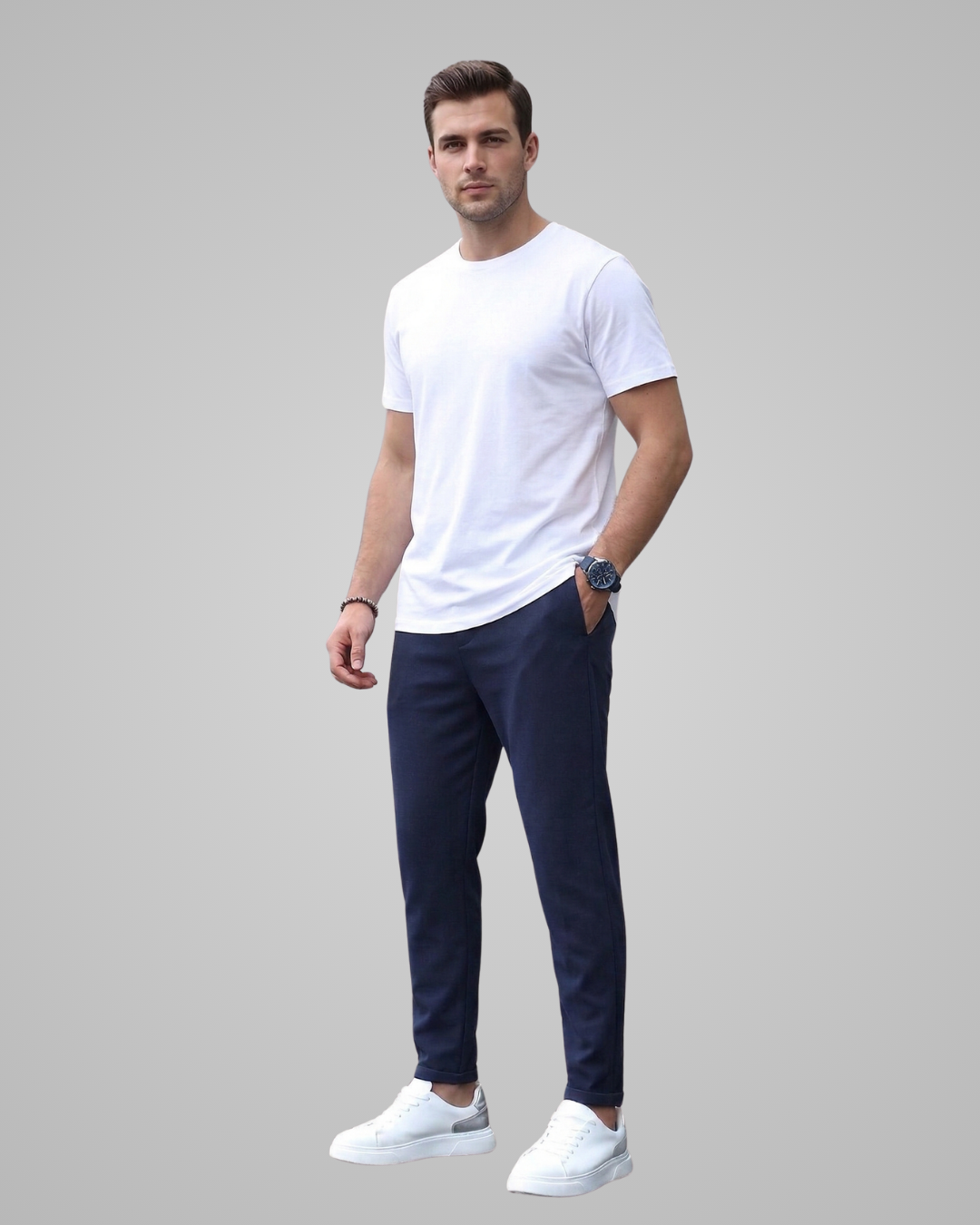 Man wearing a white t-shirt and navy pants on a gray background