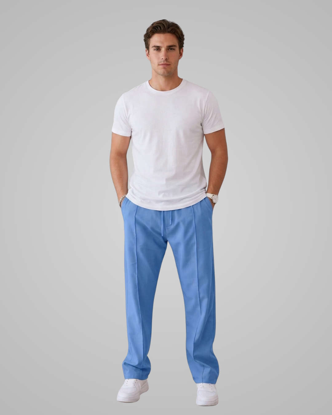 Man wearing a white t-shirt and blue pants on a gray background
