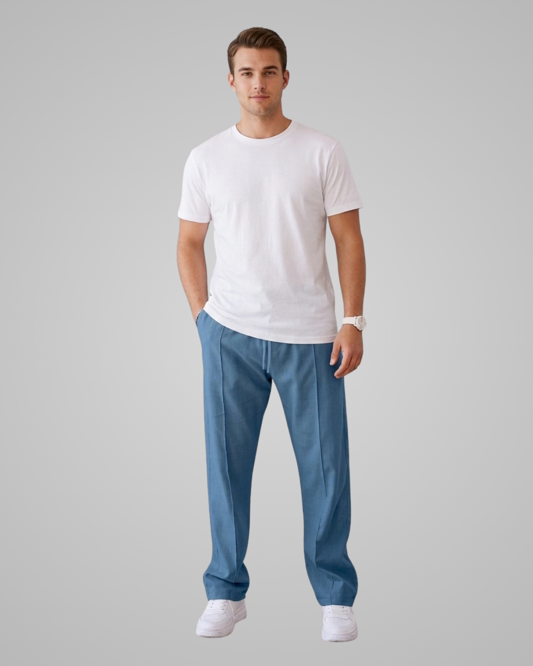 Man wearing a white t-shirt and blue pants on a gray background