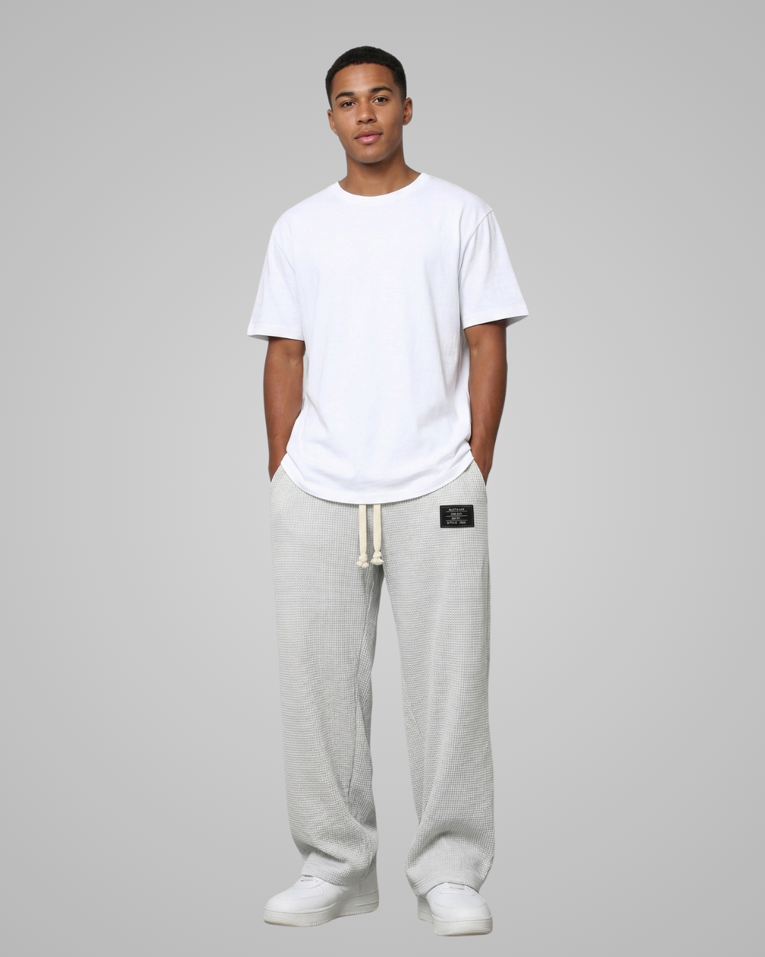 Person wearing a white t-shirt and gray sweatpants on a plain background