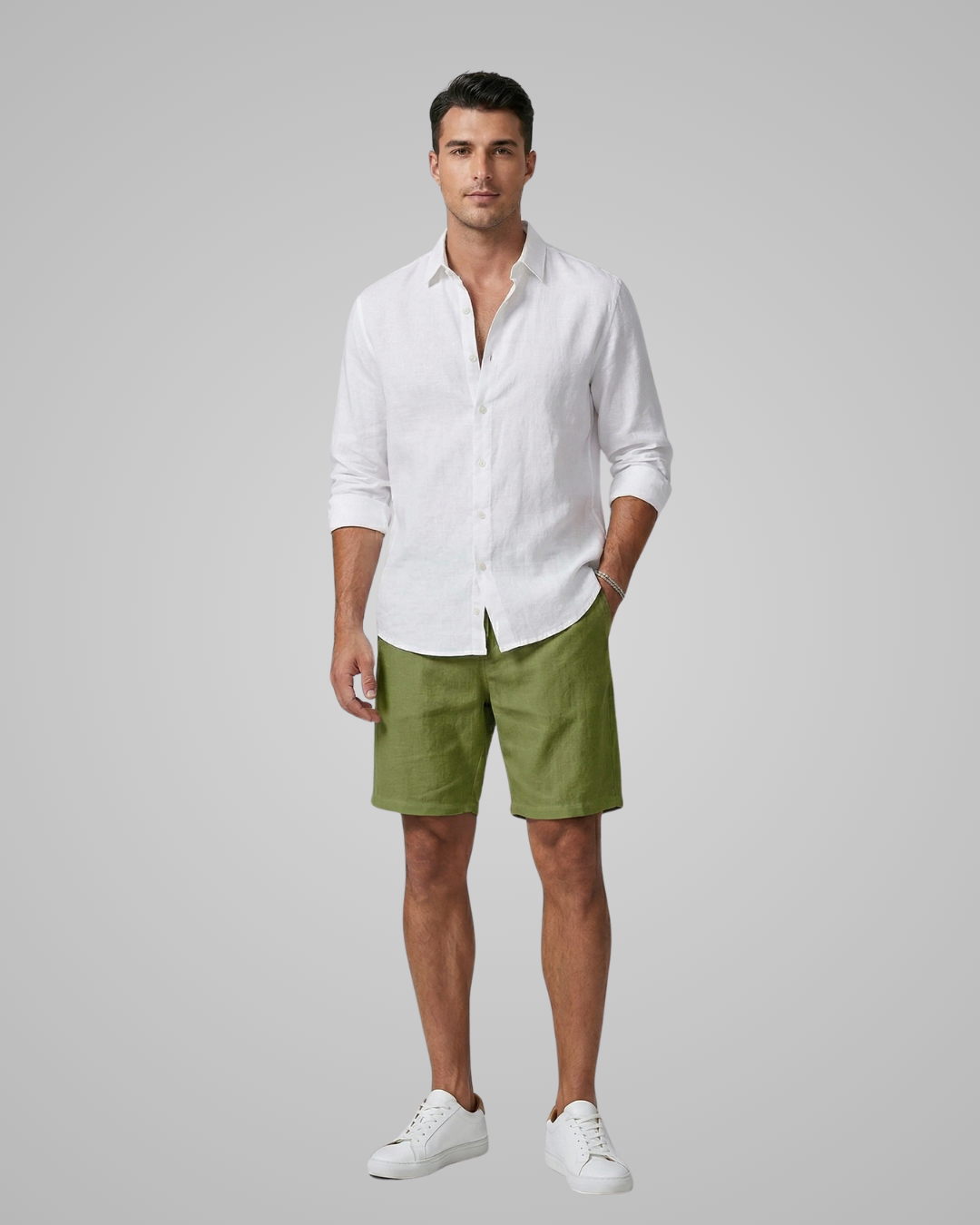 Man wearing a white shirt and green shorts on a gray background