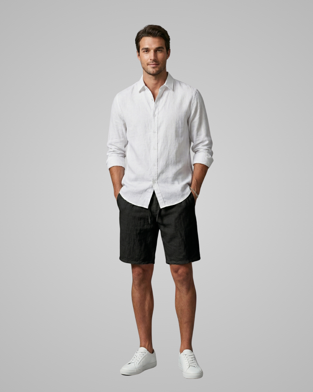Man wearing a white shirt and black shorts on a gray background