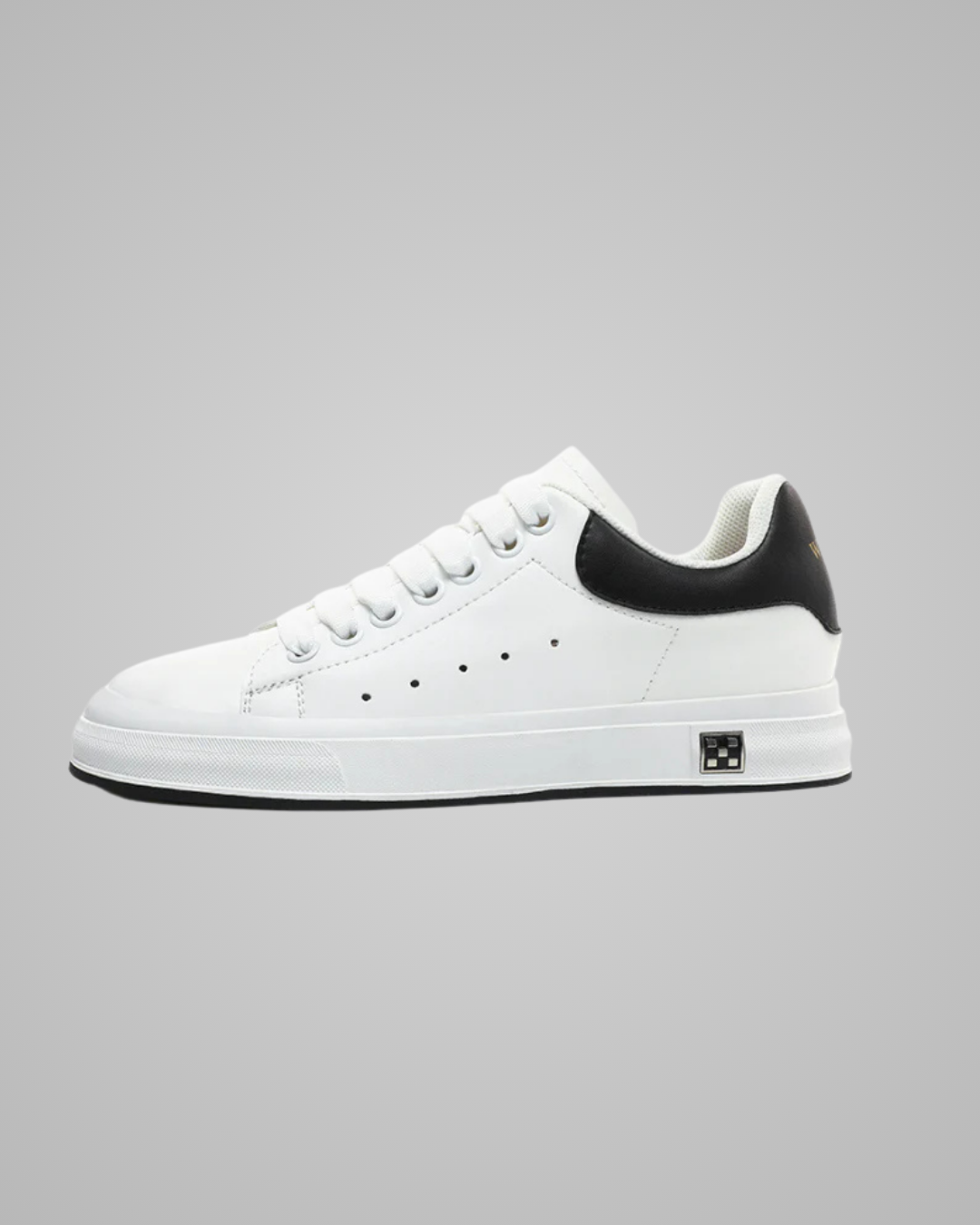 White sneaker with black heel on a gray background