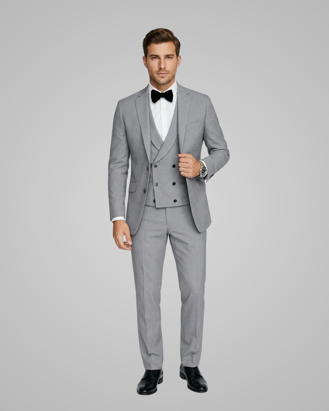 Man wearing a gray suit with a white shirt and black bow tie on a gray background