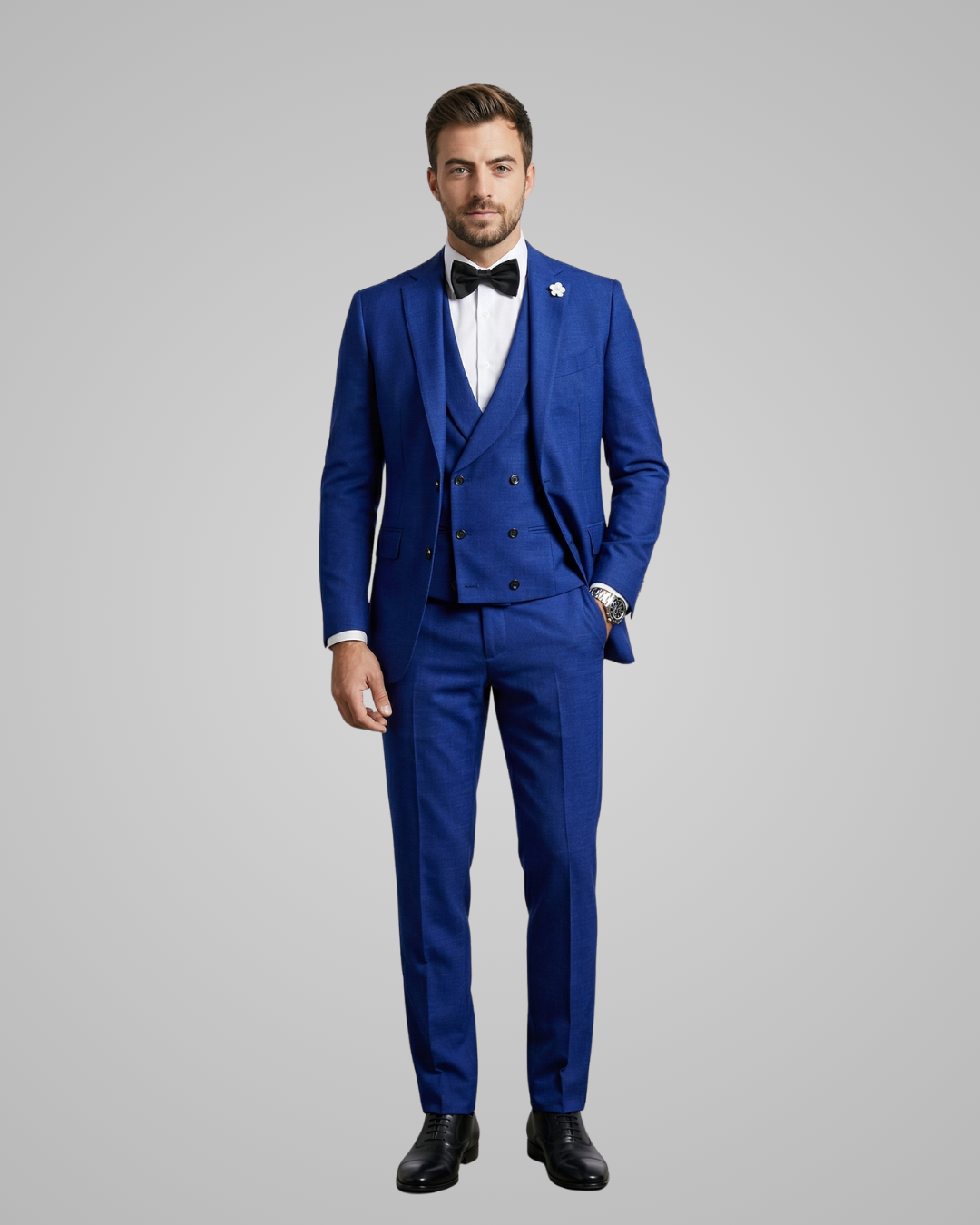 Man wearing a blue suit with a white shirt and black bow tie on a gray background