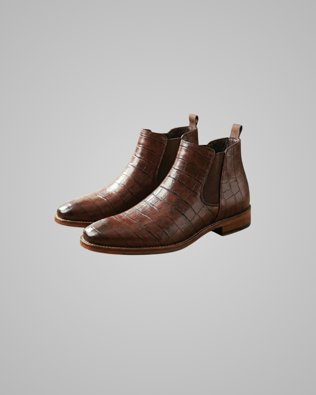 Pair of brown leather Chelsea boots on a gray background