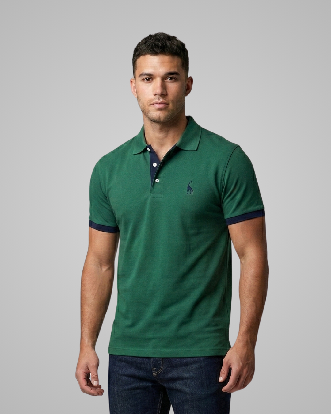 Man wearing a green polo shirt with a small logo on a gray background