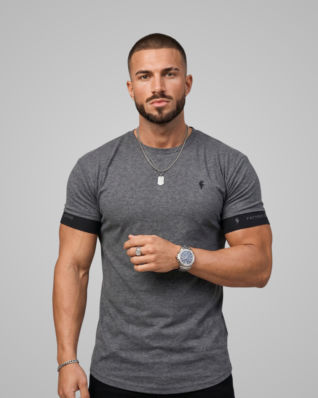 Man wearing a gray t-shirt with black sleeves on a gray background