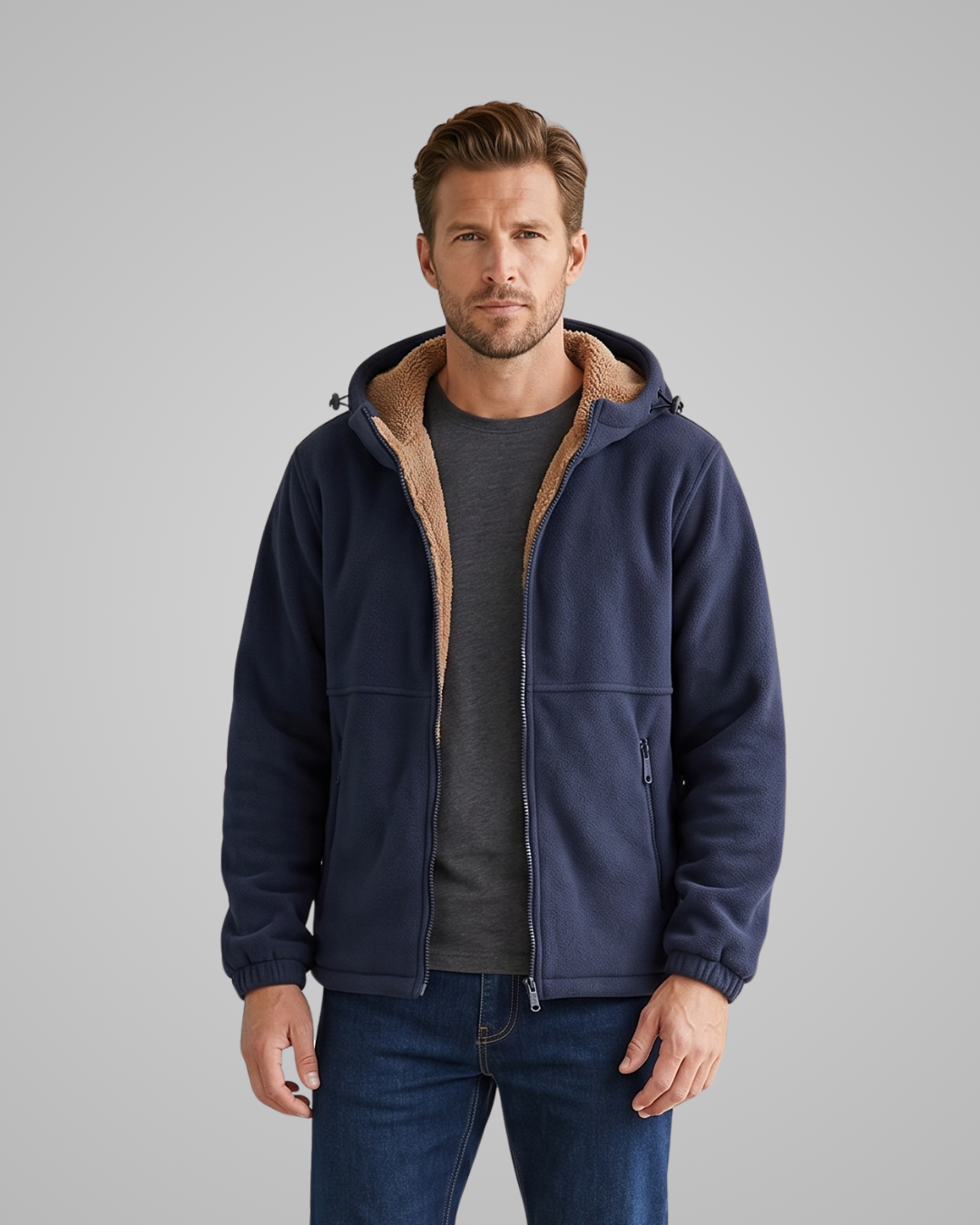 Man wearing a navy fleece jacket with brown hood on a gray background