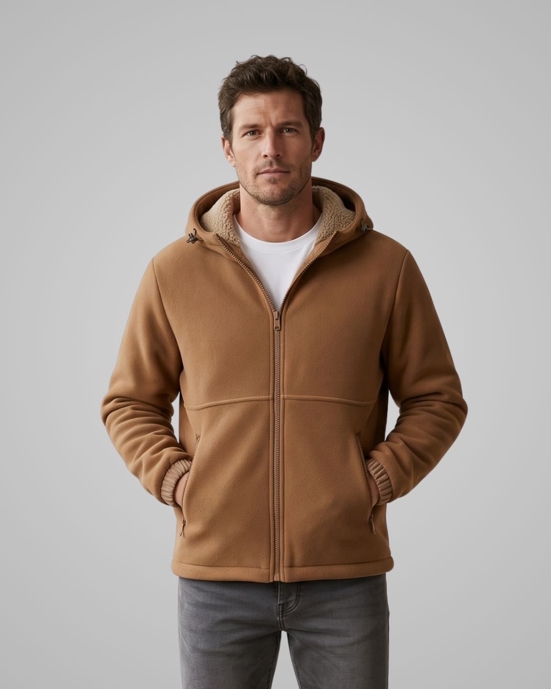 Man wearing a brown fleece jacket with a hood on a gray background